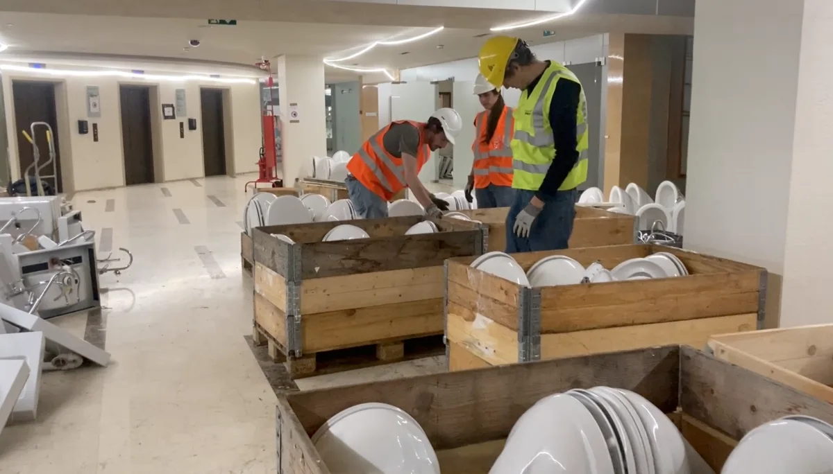 Ouvriers déballant des équipements sanitaires issus du réemploi dans un bâtiment en rénovation — DÉFI 2025