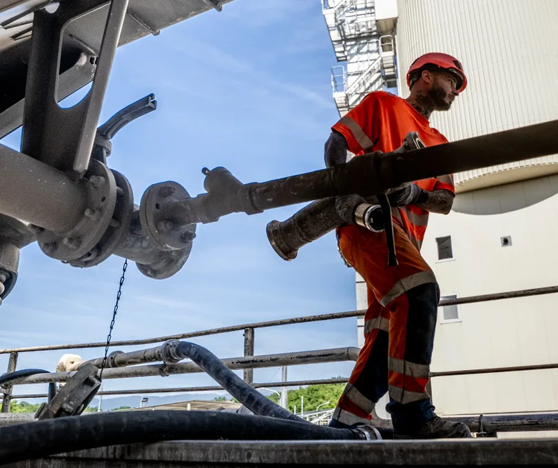 Ouvrier manipulant une canalisation dans une installation industrielle